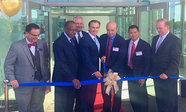 Executives cut ribbon at recent ceremony for WuXi AppTec's third facility at Philadelphia's Navy Yard. At right is Bill Hankowsky, CEO of Liberty Property Trust.
